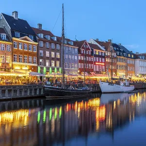 Colourful houses, restaurants and historic ships on the Nyhavn canal and harbour at dusk Colourful houses, restaurants and historic ships on the Nyhavn canal and harbour at dusk