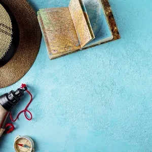 Compass, atlas, hat, flask on a blue background