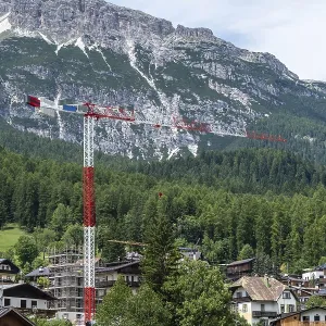 Construction crane against a mountain backdrop in the Dolomites