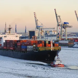 Container ship on the Elbe river in the wintery port of Hamburg Container ship on the Elbe river in the wintery port of Hamburg