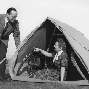 Couple, camping, woman sitting in a tent with two bicycles Couple, camping, woman sitting in a tent with two bicycles