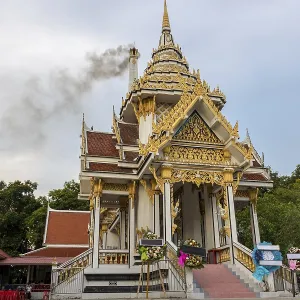 Crematorium in Buddhist monastery with smoke rising from chimney after funeral ceremony