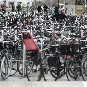 Crowded bicycle parking with numerous bikes lined up tightly along a busy street in Copenhagen Crowded bicycle parking with numerous bikes lined up tightly along a busy street in Copenhagen