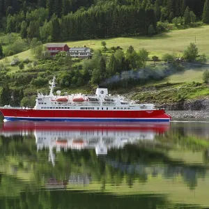 A cruise ship is reflected on a calm fjord in front of a green landscape A cruise ship is reflected on a calm fjord in front of a green landscape