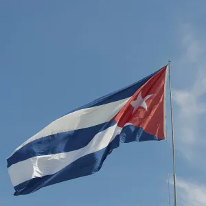 Cuba flag against blue sky and sunshine Cuba flag in front of blue sky and sunshine