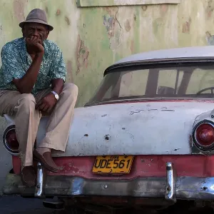 Cuban taxi driver with his vintage taxi Cuban taxi driver with his vintage taxi