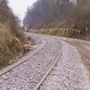 Curvy train tracks meander through a wooded Curvy train tracks meander through a wooded