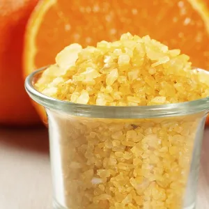 Cut orange and glass bowl with yellow sea salt on wooden desk Cut orange and glass bowl with yellow sea salt on wooden desk