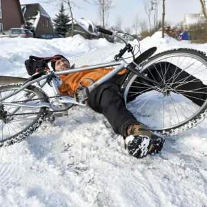 Cyclist crashing on a snow-covered slippery road