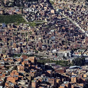 Dense urban development with many brick buildings in hilly surroundings