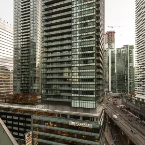 Dense urban skyline featuring towering modern skyscrapers and a busy roadway below in Toronto