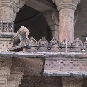 A detailed close-up of ancient stone carvings on an ornate structure featuring an elephant statue