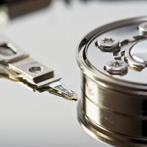 A detailed close-up image showing the read-write arm of a hard drive in precise detail