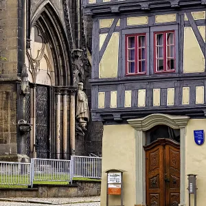 Detailed view of a church portal next to a half-timbered house Detailed view of a church portal next to a half-timbered house