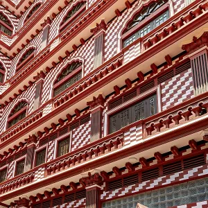Detailed view of a red building facade with symmetrical window and pattern design