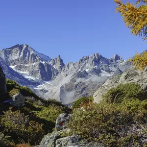 Distinctive, rocky mountain peaks with remnants of snow and surrounding vegetation