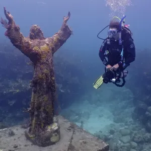 Diver looking at the statue of Jesus Christ underwater (Christ of the Abyss)