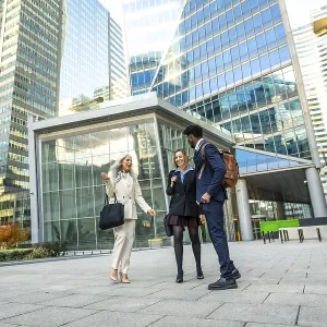 Diverse business professionals having a conversation while walking together through a modern urban financial district