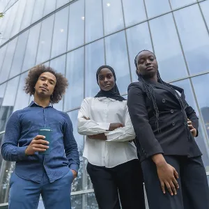 Diverse business team of young professionals standing together with confident expressions against a backdrop of a