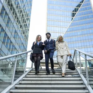 Diverse group of business people collaborating and walking down stairs in a modern financial district