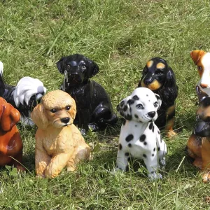 Dog breed statues on a grass background