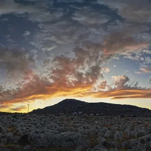Dramatic landscape of Lindos with a mountain in the background and colourful sunset in the sky