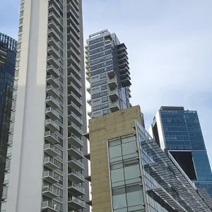Dramatic perspective of high-rise buildings with glass facades standing out against the blue sky Dramatic perspective of high-rise buildings with glass facades standing out against the blue sky