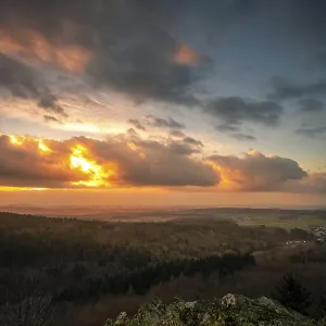 A Dramatic Sunset in the Evening with Clouds over a Valley in the Forest