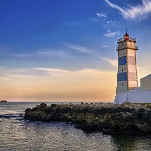 Dramatic sunset on sea shore and Santa Marta lighthouse in Cascais