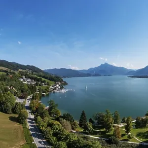 Drone shot, lakeside promenade with Schafberg and Drachenwand