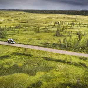 Drone view, aerial photo, motorhome (Ford Ranger with body Oman) on gravel road in wetland Drone view, aerial photo, motorhome (Ford Ranger with body Oman) on gravel road in wetland