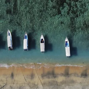 A drone view of an idyllic beach with moored boats in Indonesia A drone view of an idyllic beach with moored boats in Indonesia