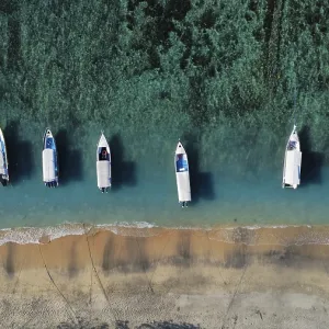 A drone view of an idyllic beach with moored boats in Indonesia A drone view of an idyllic beach with moored boats in Indonesia