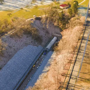 Drone view of a railway line through an autumn landscape with meadows and forests Drone view of a railway line through an autumn landscape with meadows and forests