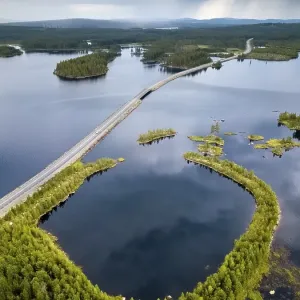 Drones shot, winding road runs through lake landscape Drones shot, winding road runs through lake landscape