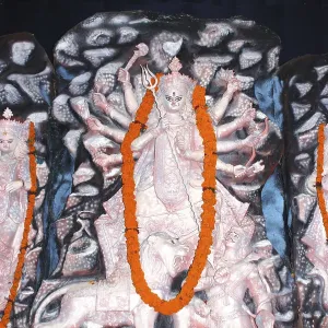 Durga clay model holding weapons killing demon on Durga puja