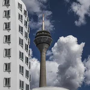 The Dusseldorf Rhine Tower rises behind the distinctive facade of one of the Gehry buildings