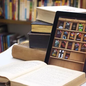 E-book reader beside a stack of old books, Germany