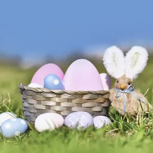 Easter basket with painted eggs and chick with rabbit ears on meadow Easter basket with painted eggs and chick with rabbit ears on meadow