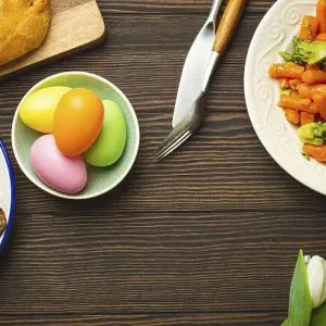 Easter food on dark rustic table: pastel colored eggs