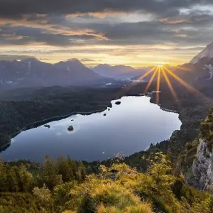 Eibsee lake at sunrise, sun shining over Bavarian alpine foothills Eibsee lake at sunrise, sun shining over Bavarian alpine foothills