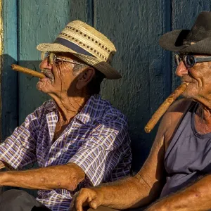 Two elderly Cubans sitting on a doorstep in the evening light