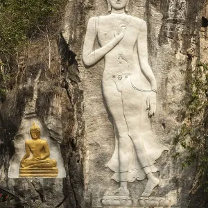 Elderly woman standing in front of a Buddha sculpture Elderly woman standing in front of a Buddha sculpture