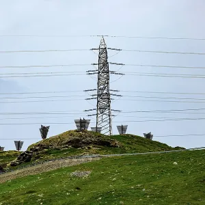 Electricity Pylon with Mountain View in the Swiss Alps in a Cloudy Summer Day in Bernina
