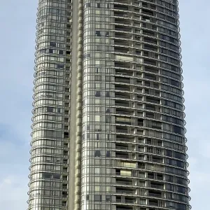 Elegant tall building with curved glass facade under a slightly cloudy sky Elegant tall building with curved glass facade under a slightly cloudy sky