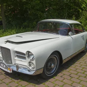 Elegant white classic car, shining in the sunlight on a paved square Elegant white classic car, shining in the sunlight on a paved square