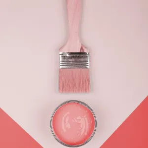 Elevated view paintbrush coral paint geometric paper background Elevated view paintbrush coral paint geometric paper background