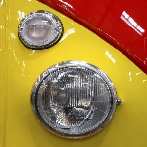 The front end of a Volkswagen bus with indicators and headlights