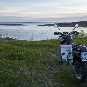 Enduro motorcycle on the Norwegian coast in the evening twilight