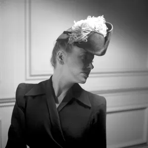 England 1945. A fashionable young woman wearing a creative hat and decoration
